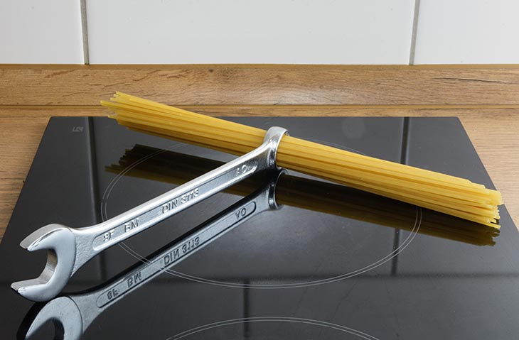 ein Ringschlüssel als Nudellineal mit Spaghetti