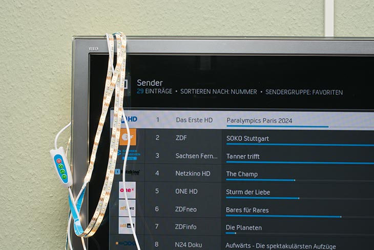 Ein USB-Lichtstreifen hängt zum Test an einem Fernseher.